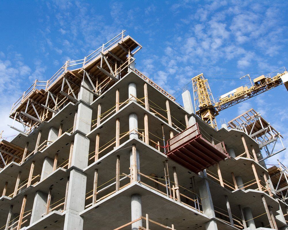 Building under construction with yellow crane.