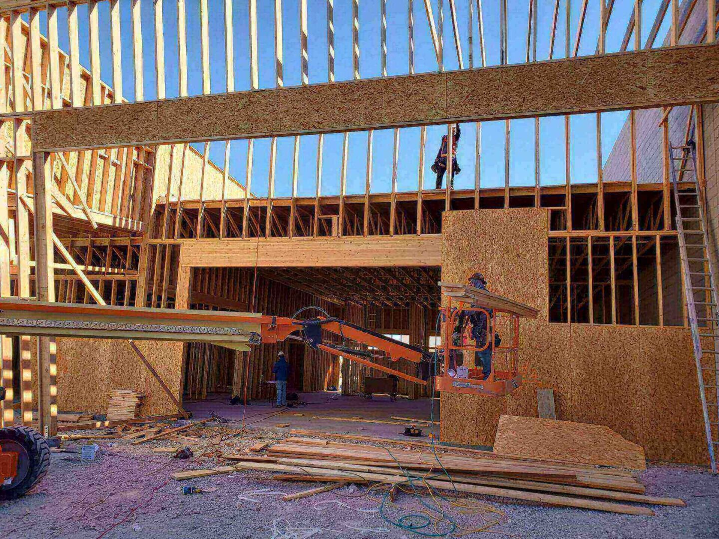 Construction site with wooden framework and workers.